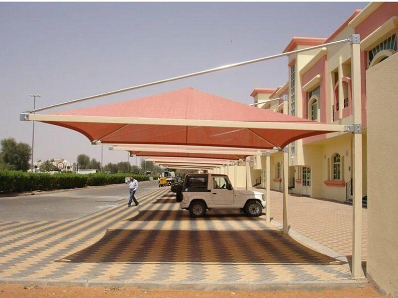 pyramid shaped car oof car shed with shade net roofing structure protecting parked vehicles in a residential parking area.